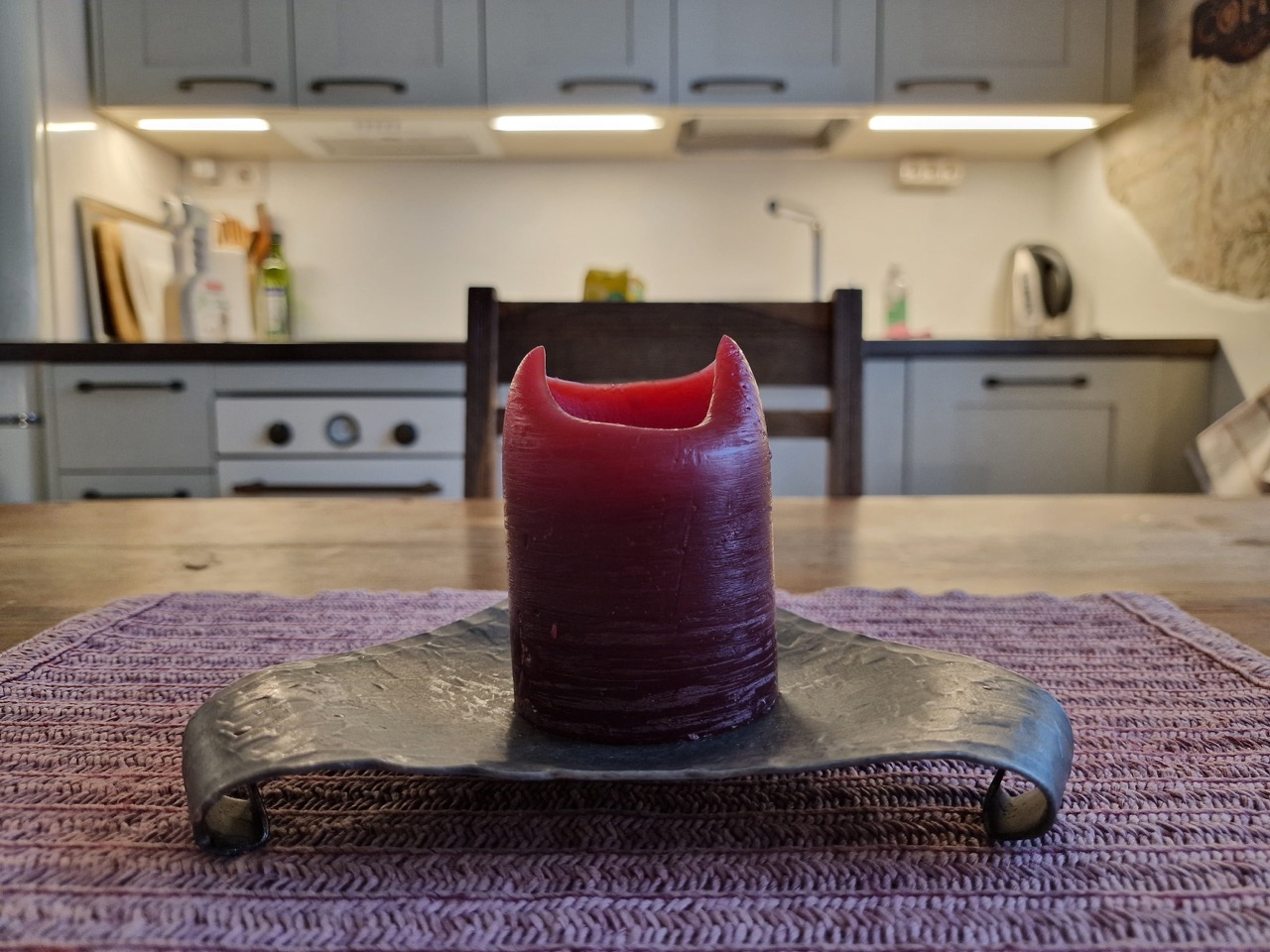 View of kitchen area and candle on tabletop