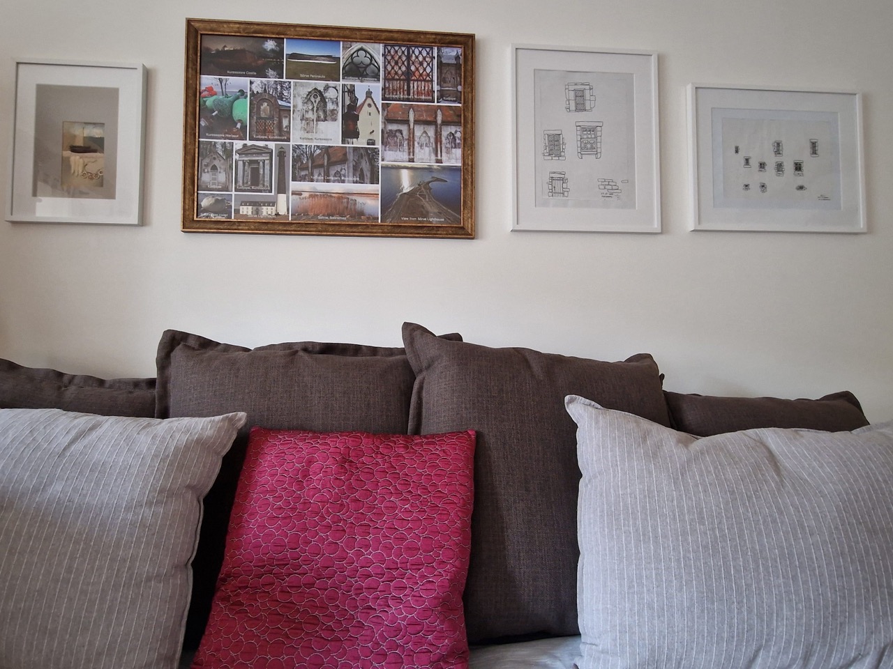 Sofa-bed with cushions and pictures on wall
